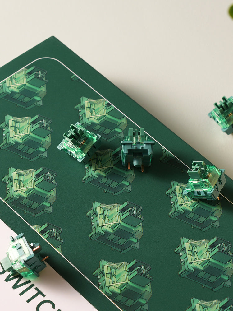 A collection of V3 Matcha Green Pro Switches on the green pad